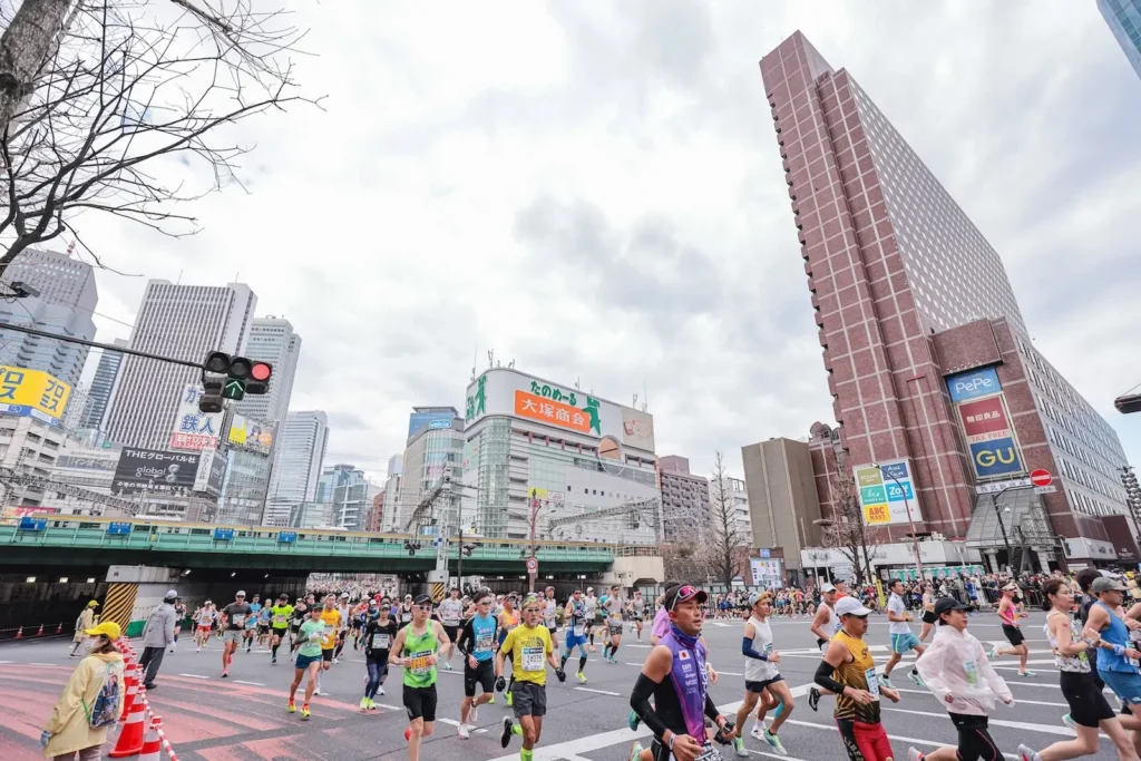Corredores durante el Maratón de Tokio con clima fresco y cielo nublado